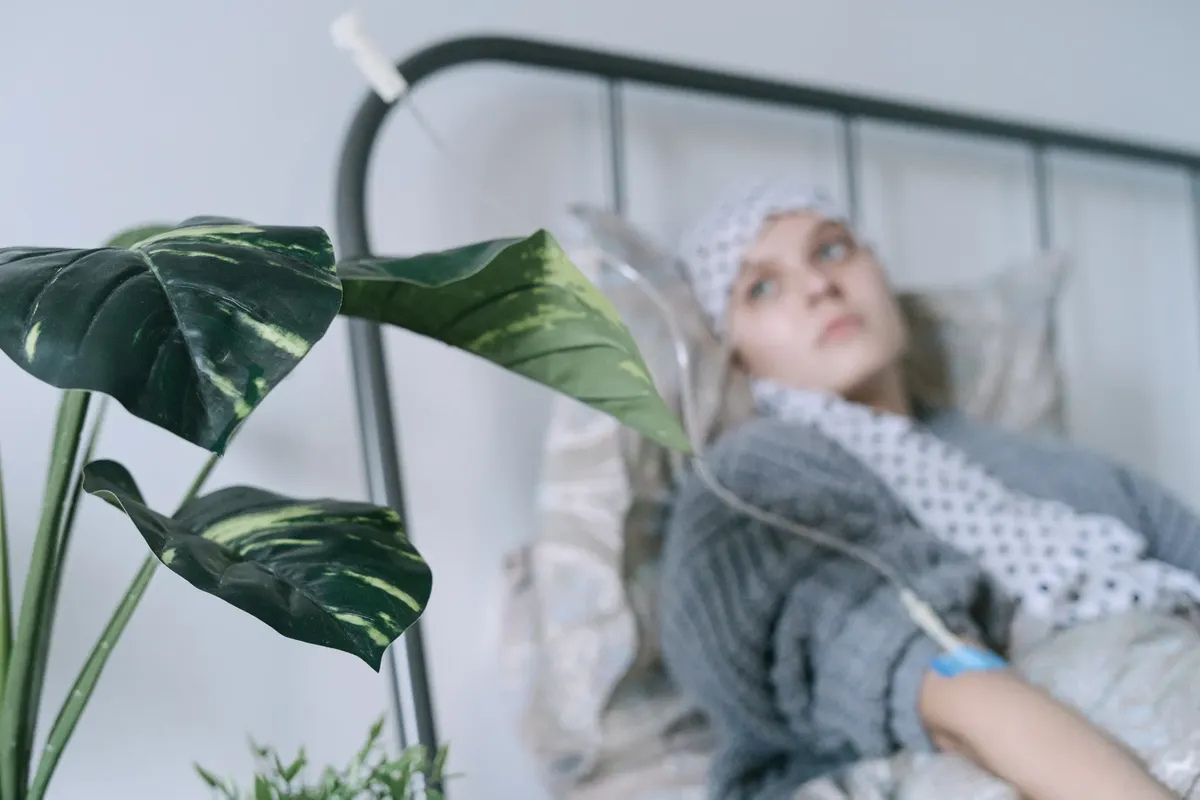 A cancer patient with an IV drip lies on a hospital bed, reflecting hope and recovery.